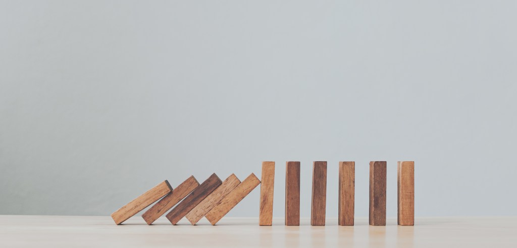 Stop wooden domino business crisis effect or risk protection concept