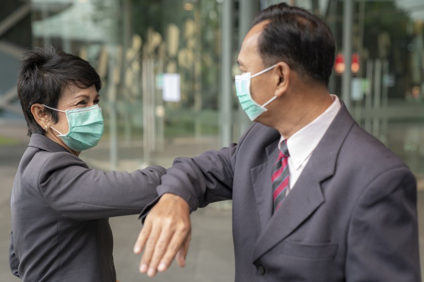 Old asian business people greeting togather by new methode with mask for prevent covid 19
