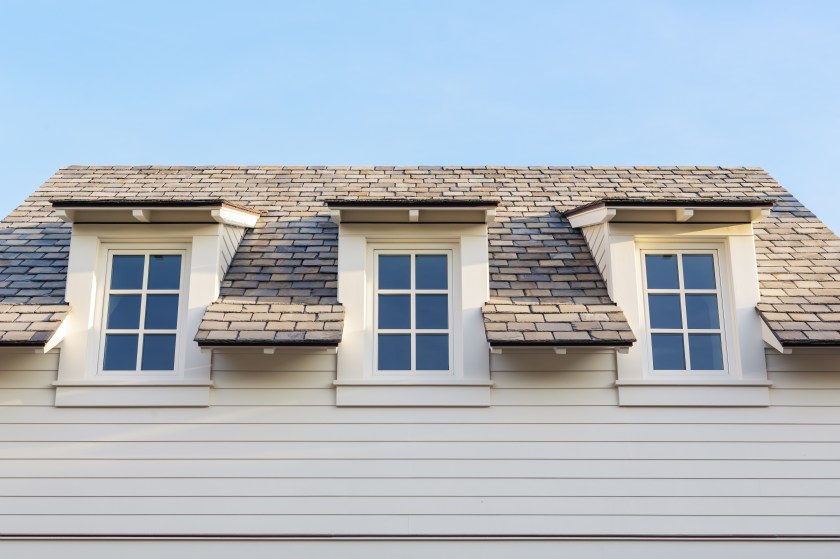 Upwards at 3 home attic windows with roof