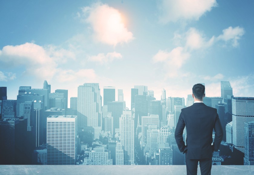 Businessman-standing-on-a-roof-and-looking-at-future-city