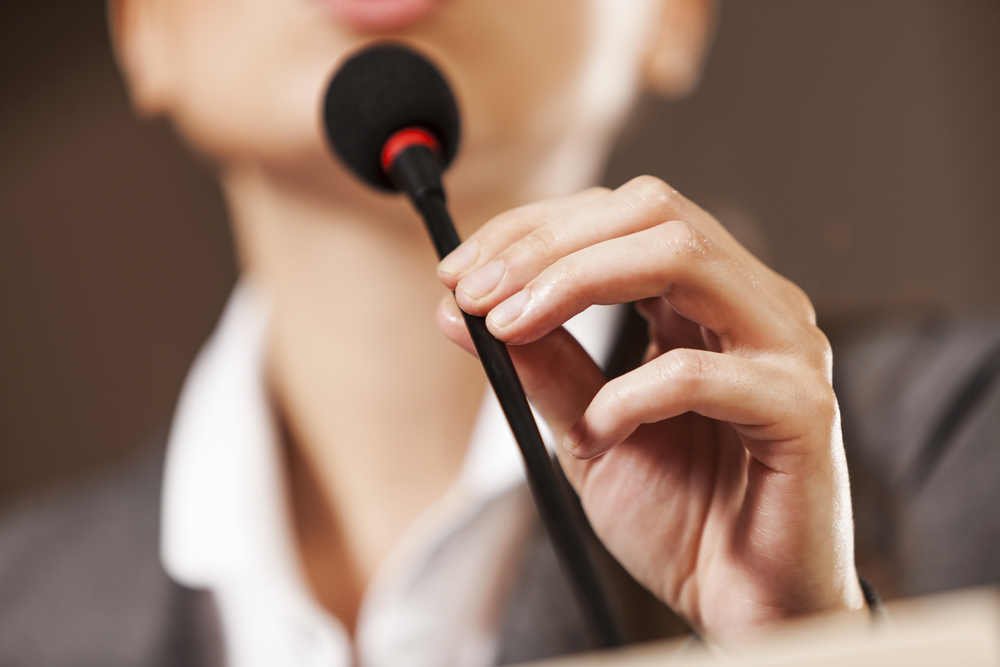Businesswoman-standing-on-stage-and-reporting-for-audience