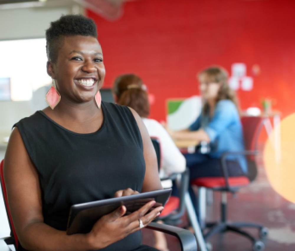 Confident-female-designer-working-on-a-digital-tablet-in-red-creative-office-space