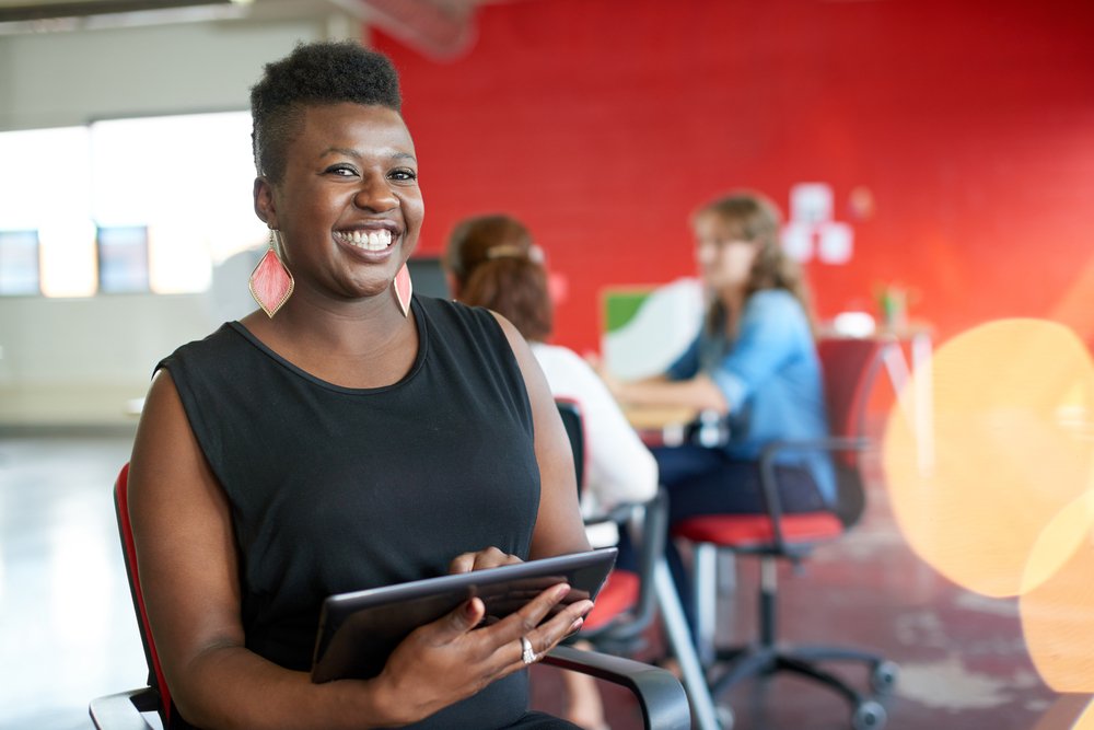 Confident-female-designer-working-on-a-digital-tablet-in-red-creative-office-space