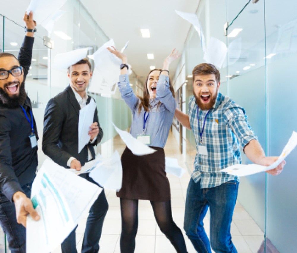 Group-of-joyful-excited-business-people-throwing-papers-and-having-fun-in-office