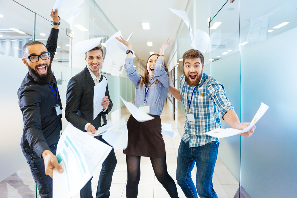 Group-of-joyful-excited-business-people-throwing-papers-and-having-fun-in-office