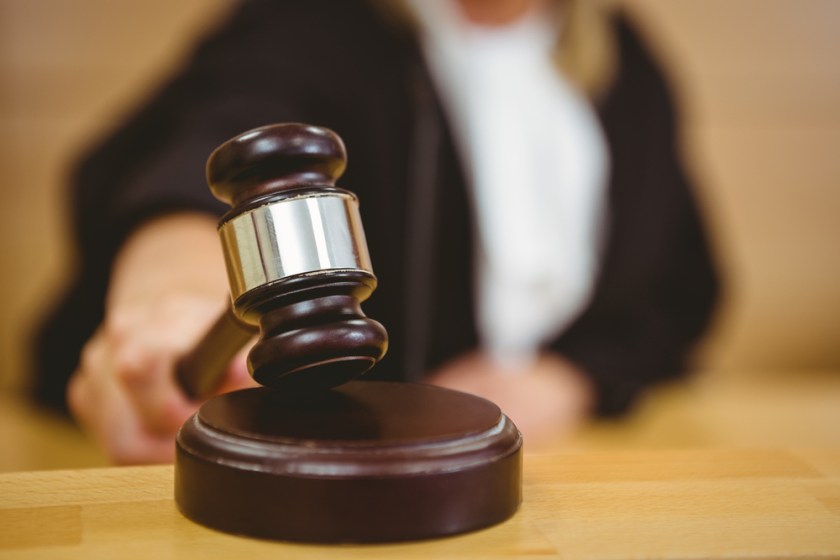 Hand-about-to-bang-gavel-on-sounding-block-in-the-court-room