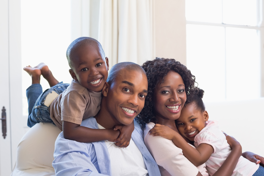 Happy-family-posing-on-the-couch-together-at-home-in-the-living-room-1