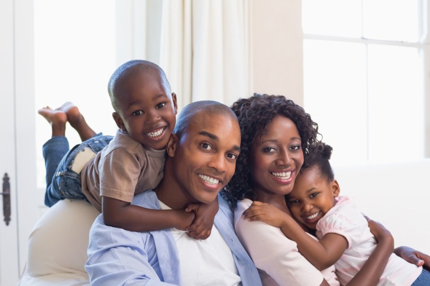 Happy-family-posing-on-the-couch-together-at-home-in-the-living-room-1