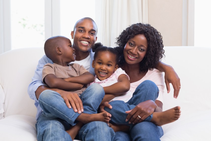 Happy-family-posing-on-the-couch-together-at-home-in-the-living-room
