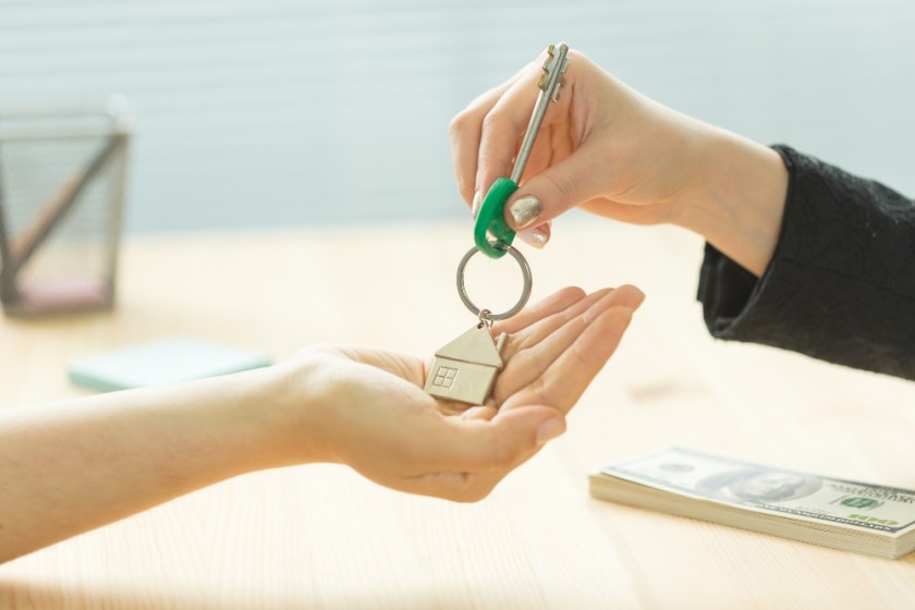 Business, realtor and real estate concept - Hand-to-hand key from new home.