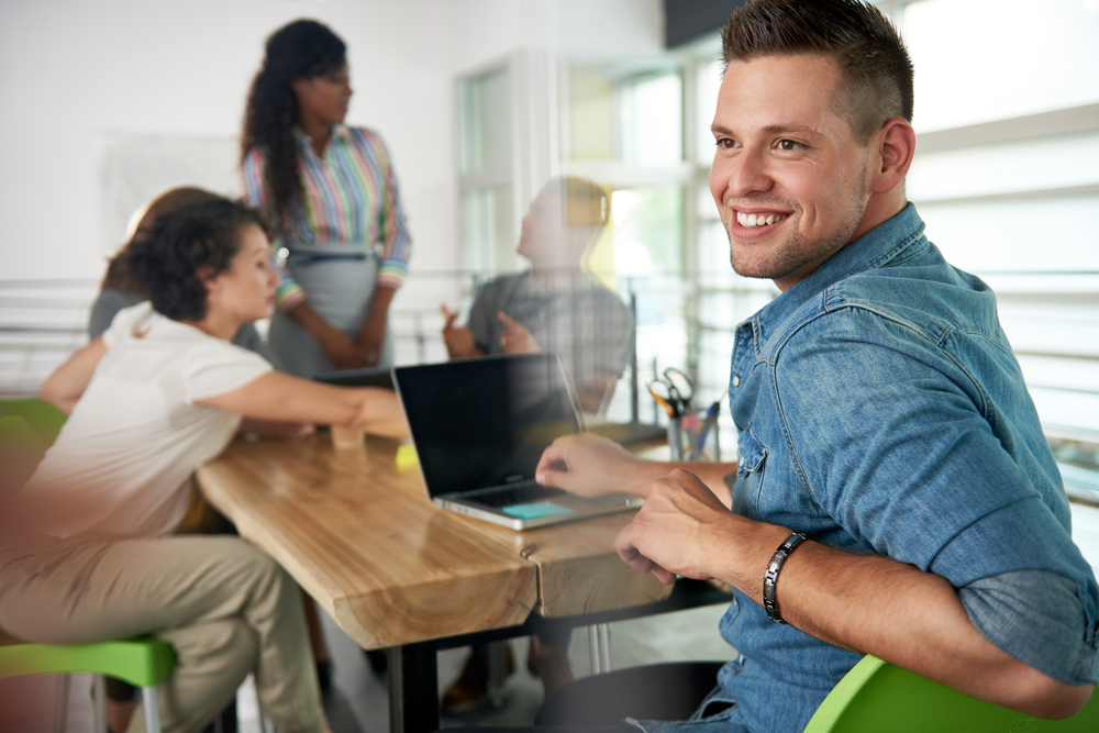 Image-of-a-succesful-casual-business-man-using-laptop-during-meeting