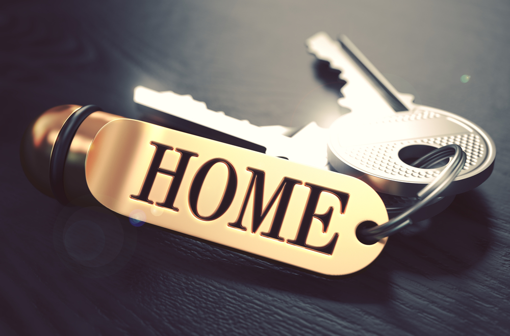 Keys-and-Golden-Keyring-with-the-Word-Home-over-Black-Wooden-Table-with-Blur-Effect.-Toned-Image.
