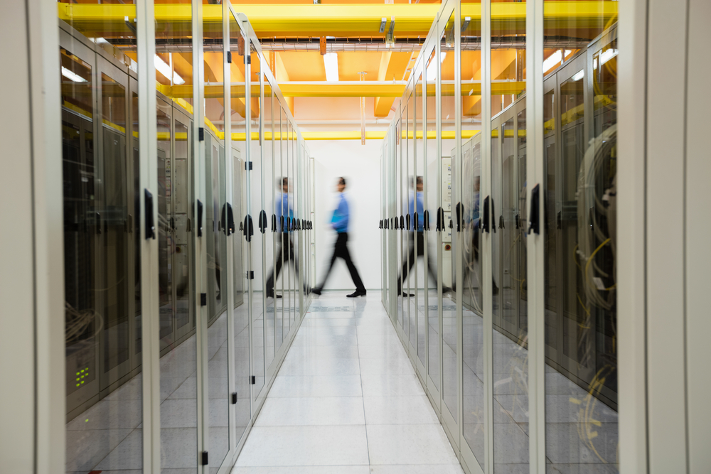 Technician-walking-in-hallway-of-server-room
