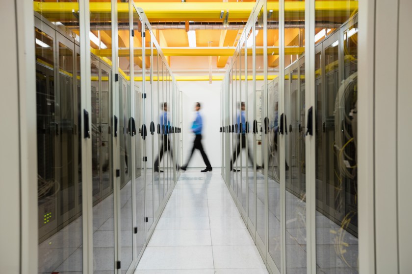 Technician-walking-in-hallway-of-server-room