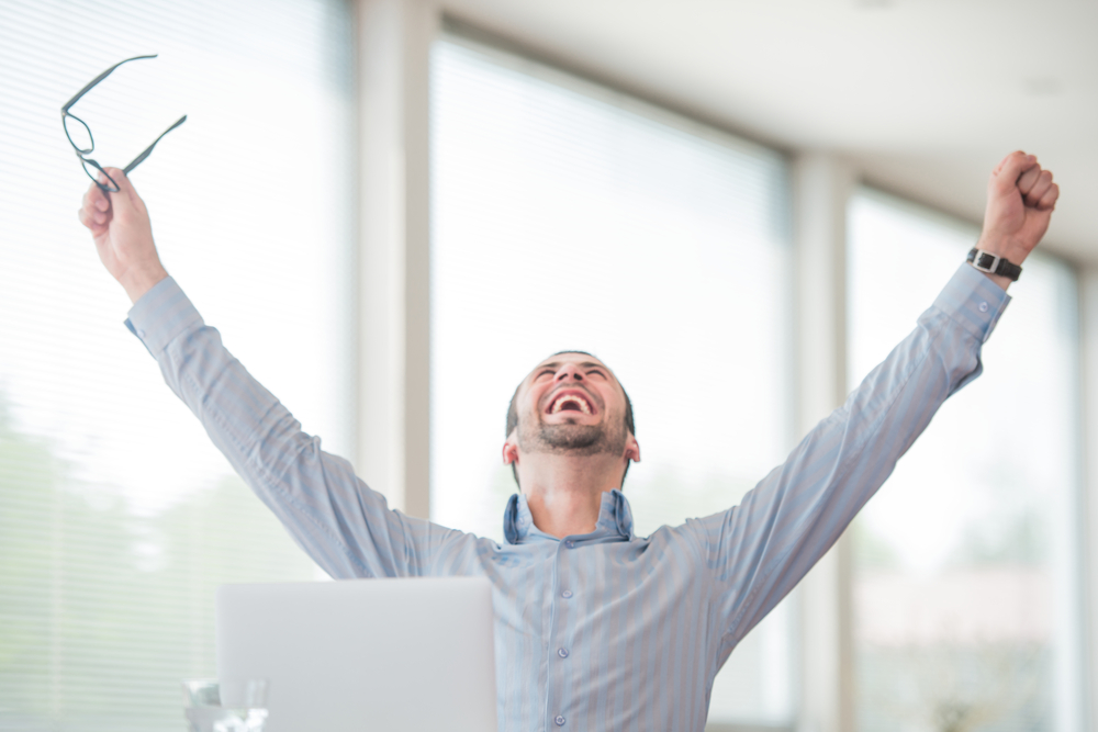 Victorious-corporate-man-celebrating-with-his-arms-lifted-in-the-air