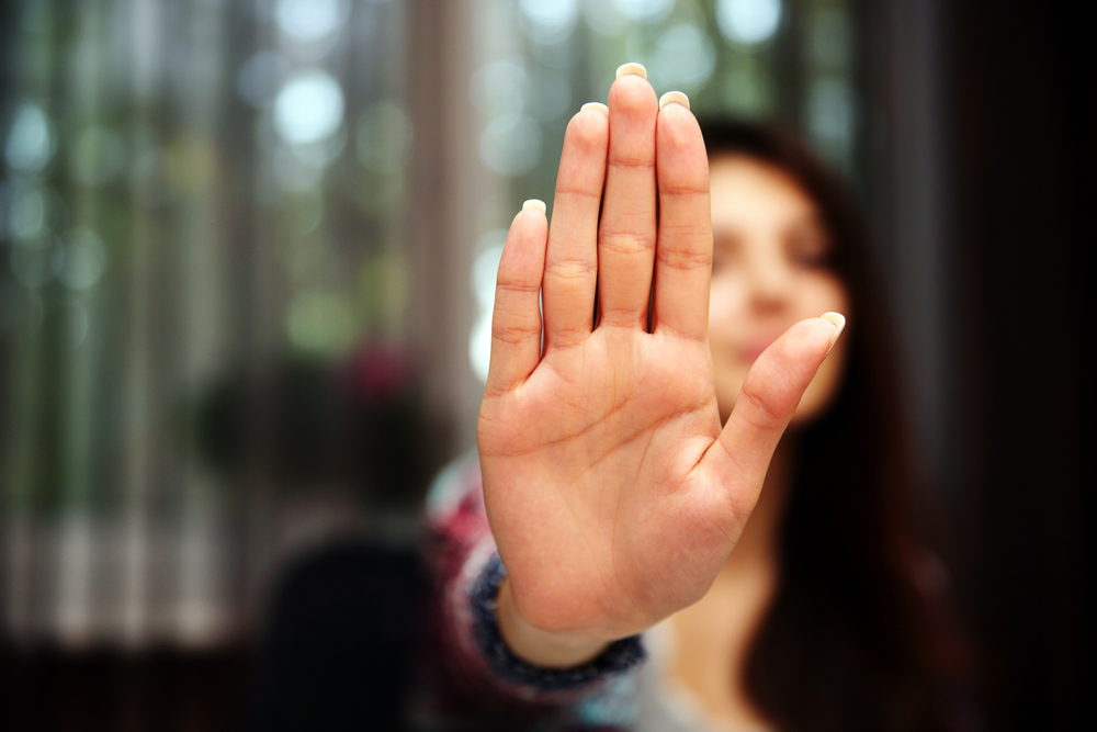 Woman-with-her-hand-extended-signaling-to-stop-only-her-hand-is-in-focus