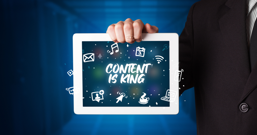 Young-business-person-working-on-tablet-and-shows-the-inscription-CONTENT-IS-KING