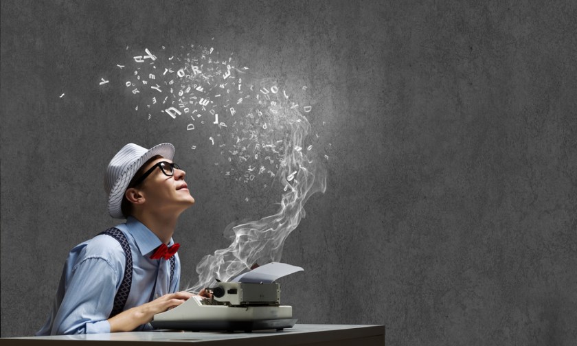 Young-funny-man-in-glasses-writing-on-typewriter