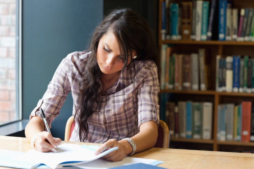 Young-student-writing-in-a-library