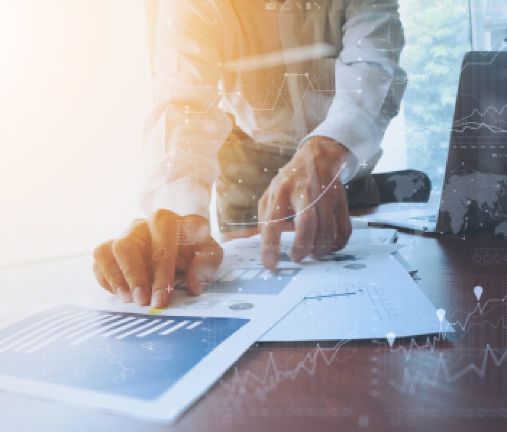 business-documents-on-office-table-with-smart-phone-and-digital-tablet-and-graph-financial-with-social-network-diagram-and-man-working-in-the-background-1