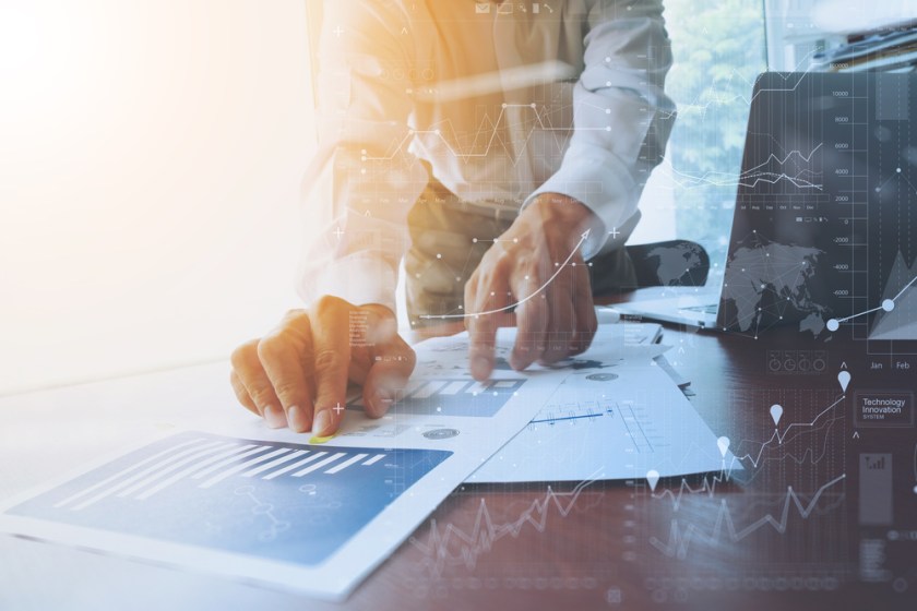 business-documents-on-office-table-with-smart-phone-and-digital-tablet-and-graph-financial-with-social-network-diagram-and-man-working-in-the-background-1