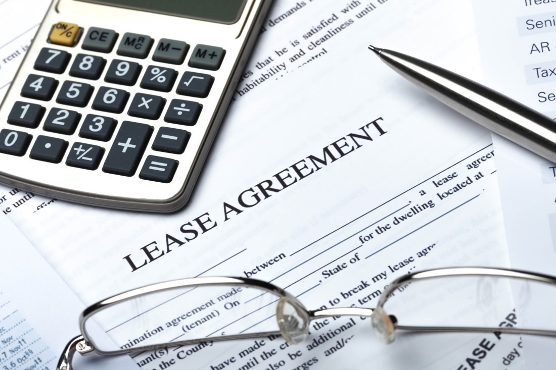 Lease Agreement Documents with Glasses, Pen and Calculator