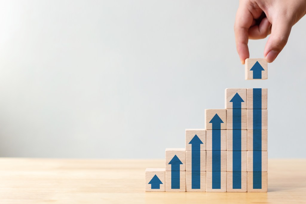 Ladder career path for business growth success process concept.Hand arranging wood block stacking as step stair with arrow up