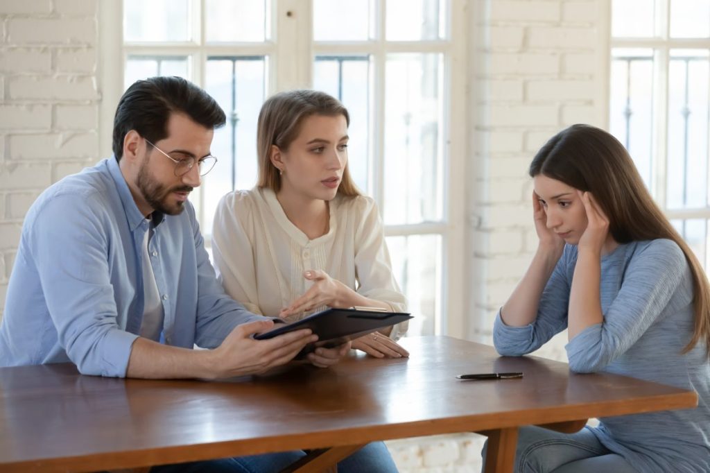 Female realtor stressed by difficult couple clients