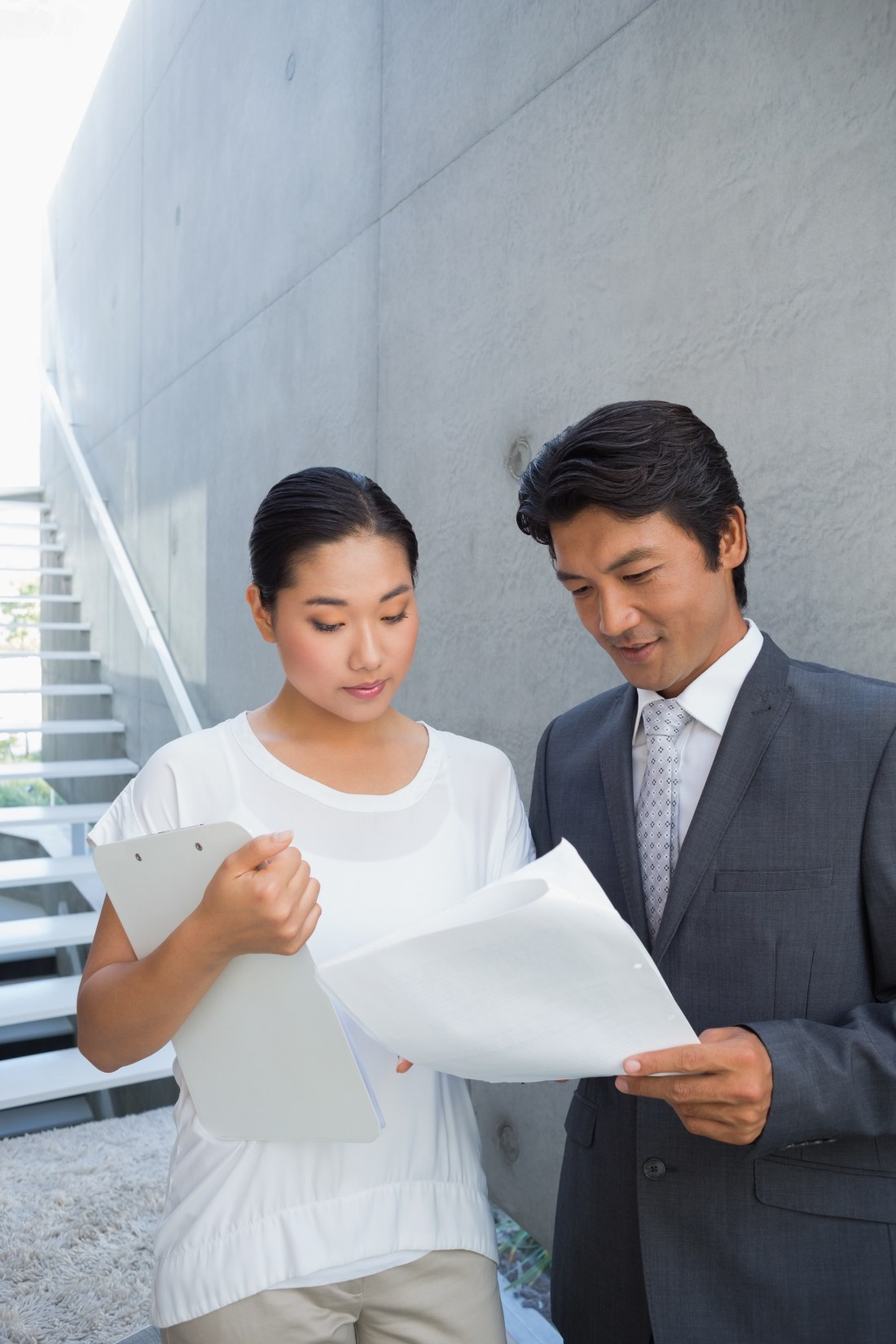 Estate agent showing lease to customer and smiling