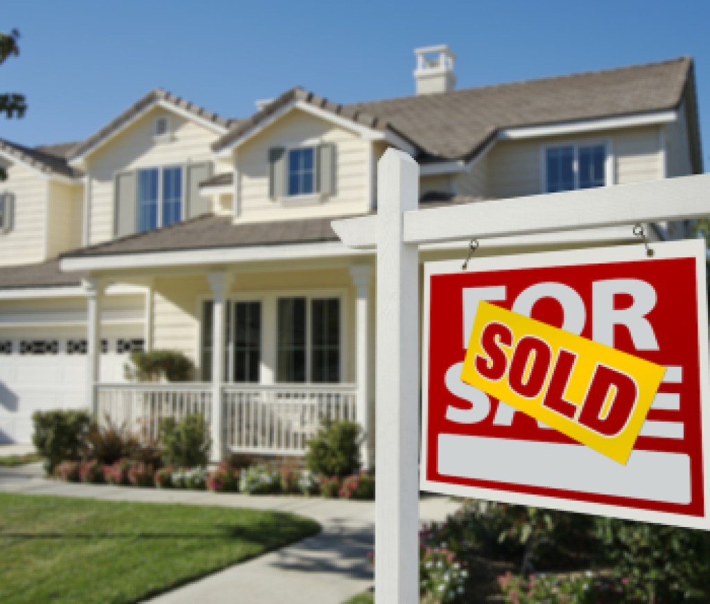 Sold Home For Sale Sign in Front of Beautiful New House.