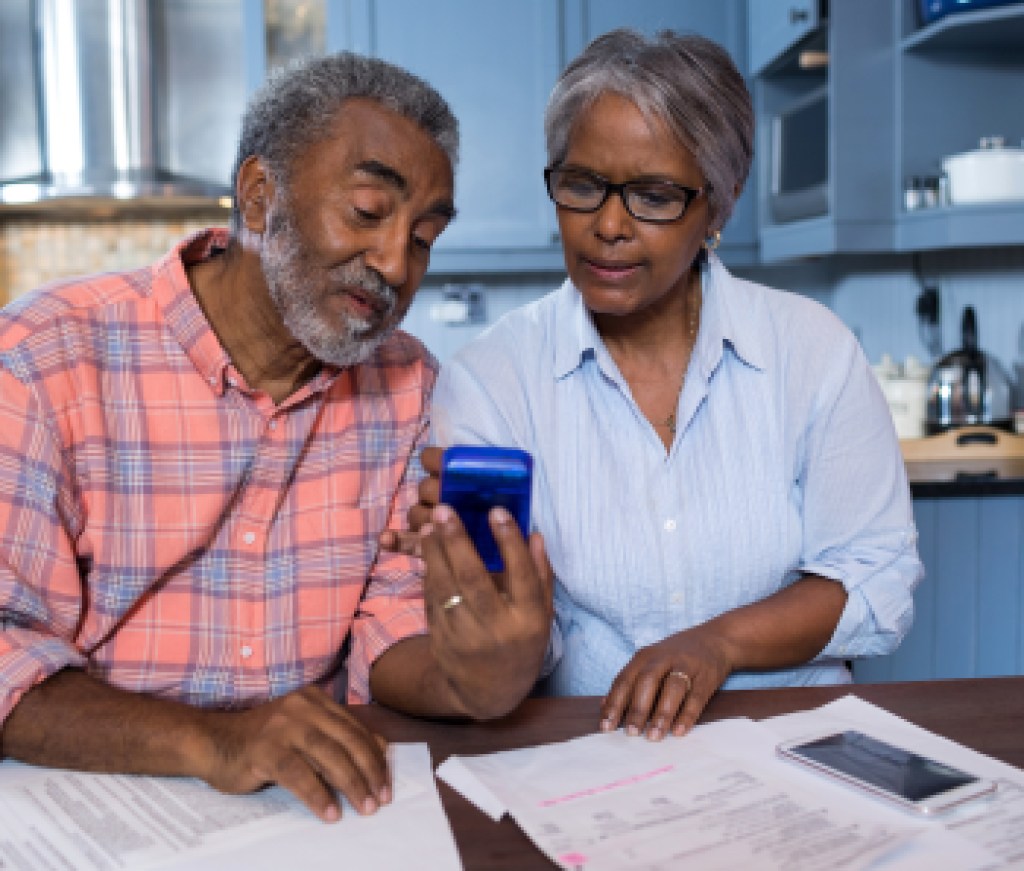 Couple using calculator in kitchen