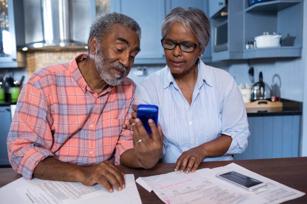 Couple using calculator in kitchen