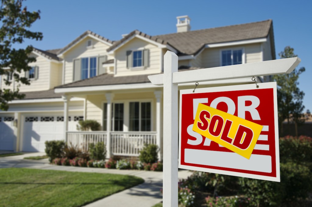 Sold Home For Sale Sign in Front of Beautiful New House.