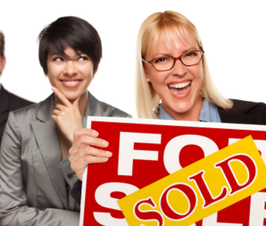 Real Estate Team Behind with Blonde Woman in Front Holding Keys and Sold For Sale Real Estate Sign Isolated on a White Background.