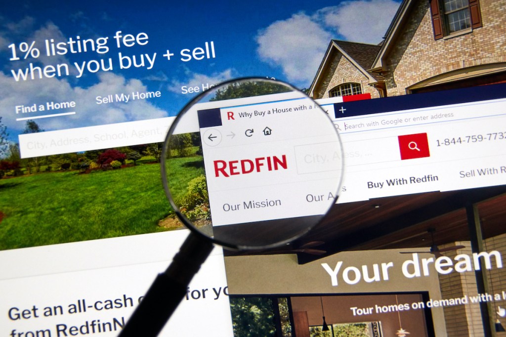 Redfin logo on official site under magnifying glass.