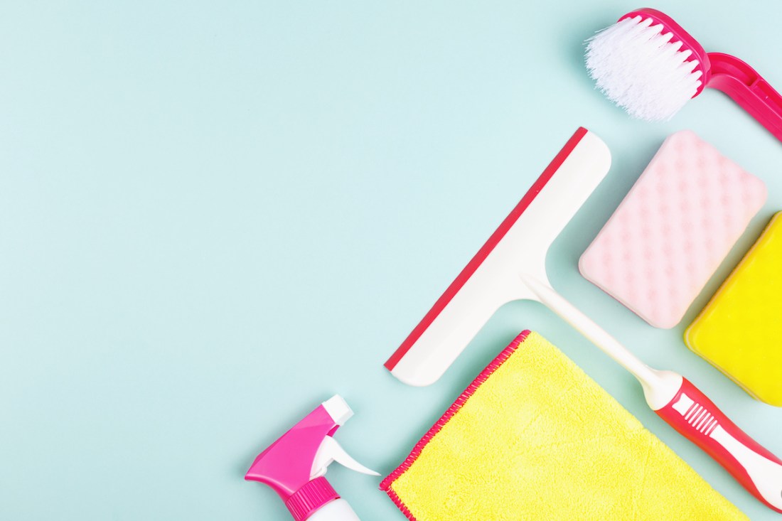Spring cleaning products on light green background
