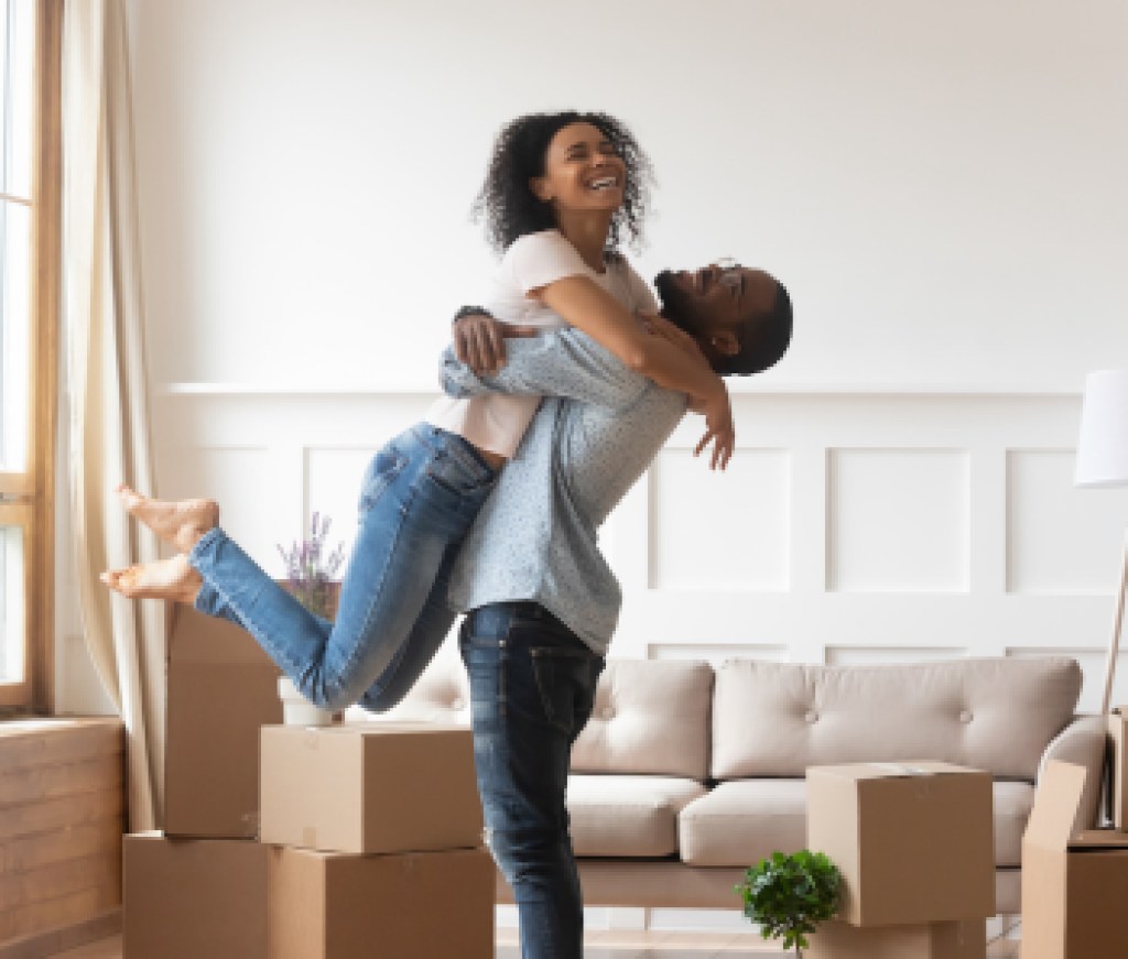 African husband lifting up wife happy family celebrating relocation day