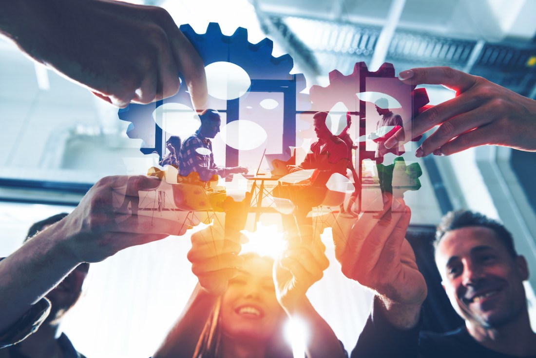 Business team connect pieces of gears. Teamwork, partnership and integration concept. double exposure with light effects