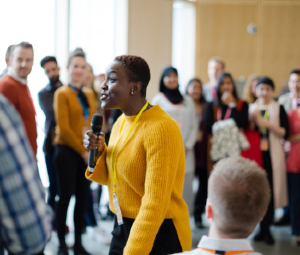 Smiling female speaker with microphone on stage
