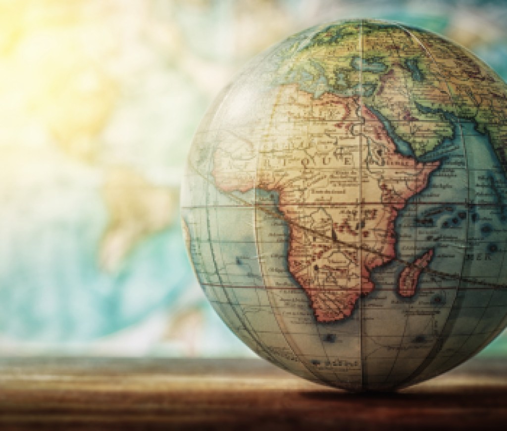 Adventure stories background. Old globe on map background. Selective focus.