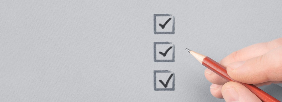 hand with pencil writing check mark on Checklist. Cropped Hand Marking On Check Box on Gray paper. Completed tasks are ticked off on a to-do list