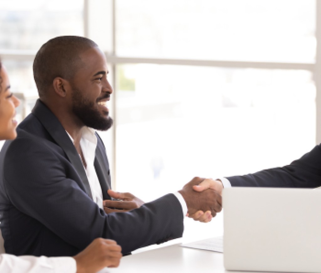 Happy sellers shake real estate agent's hand