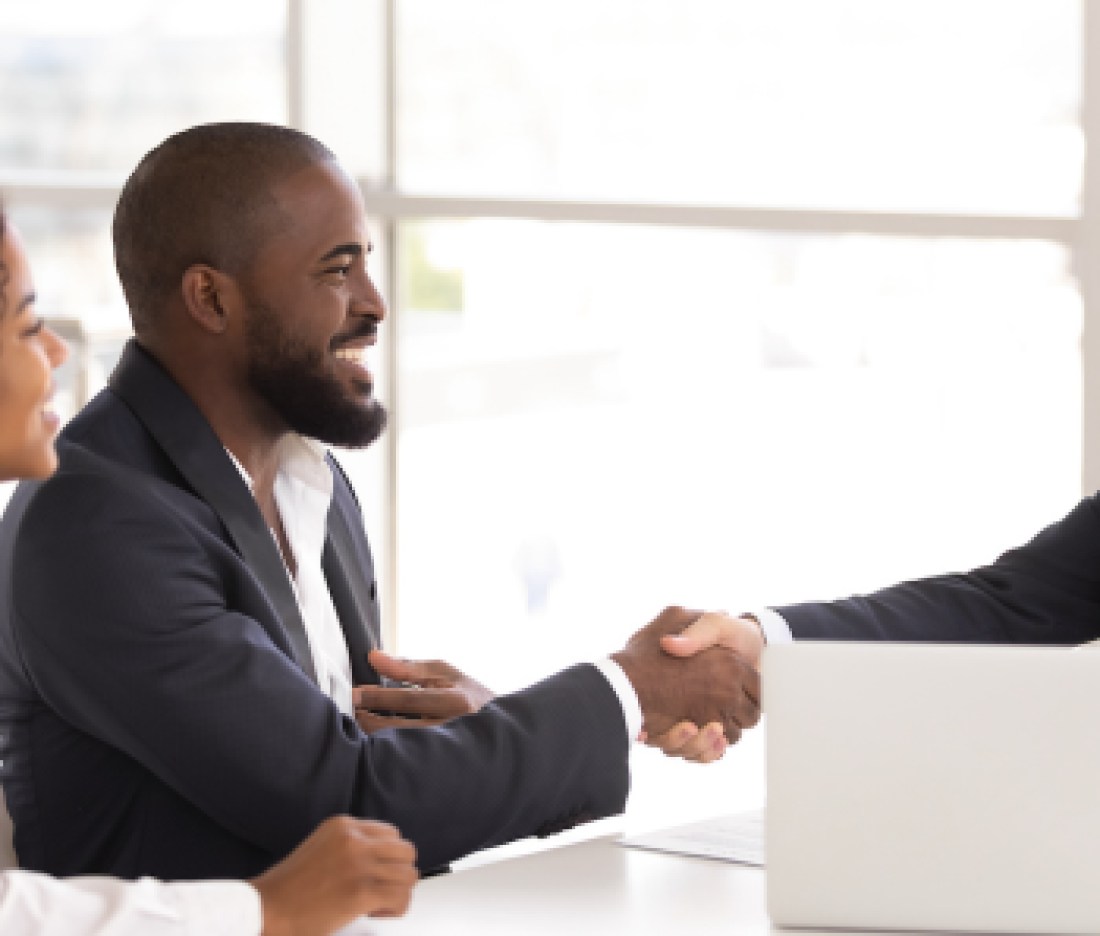 Happy sellers shake real estate agent's hand