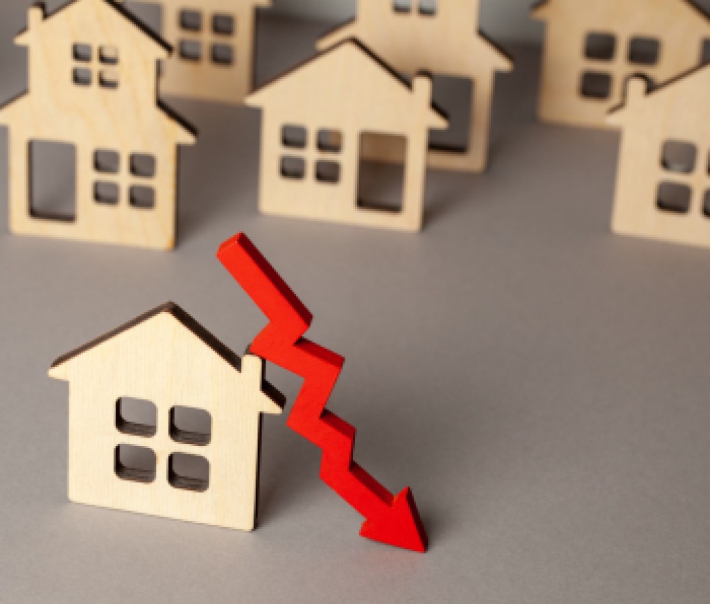 Arrow down and many houses. Falling real estate prices market. Buying and selling house