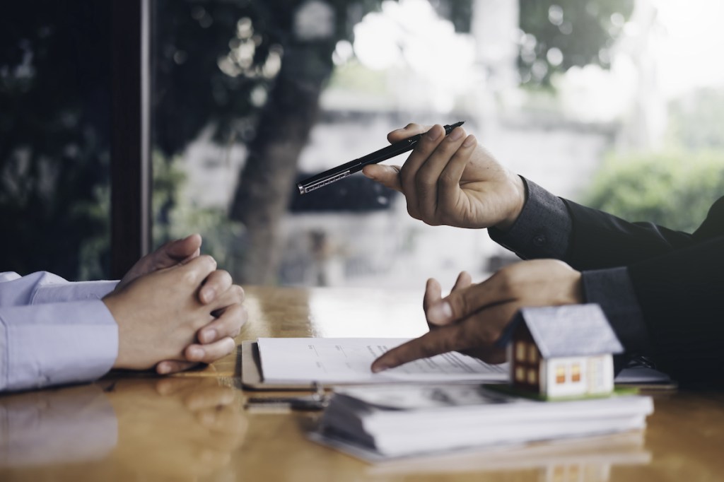 real estate agent holding house key to his client after signing contract,concept for real estate, moving home or renting property