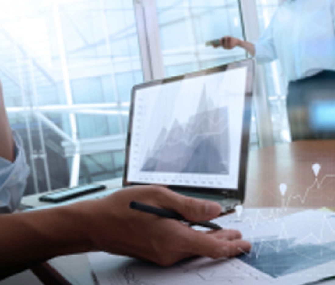 business-documents-on-office-table-with-smart-phone-and-laptop-computer-and-graph-business-with-social-network-diagram-and-two-colleagues-discussing-data-in-the-background