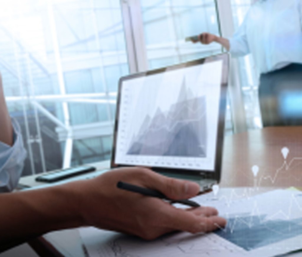 business-documents-on-office-table-with-smart-phone-and-laptop-computer-and-graph-business-with-social-network-diagram-and-two-colleagues-discussing-data-in-the-background