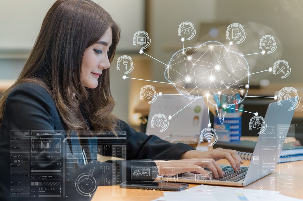 Asian businesswoman in formal suit working with computer laptop for Polygonal brain shape of an artificial intelligence with various icon of smart city Internet of Things, AI and business IOT concept