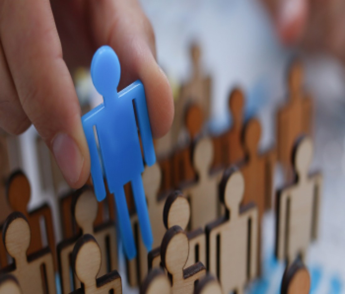 A businessman in blue shirt is holding a magnifying