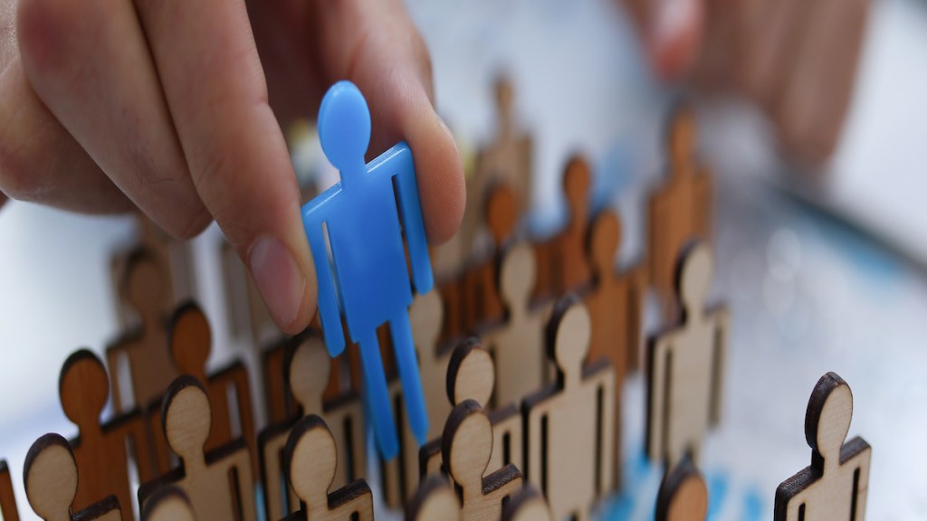 A businessman in blue shirt is holding a magnifying